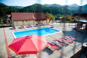 莱普沙弗洛拉汽车旅馆的享有带椅子和红色遮阳伞的游泳池的上方景色