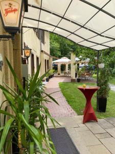 齐恩多夫佐多夫公寓酒店的遮阳篷下方的带红色桌子的庭院