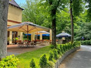 齐恩多夫佐多夫公寓酒店的公园内带桌子和遮阳伞的庭院