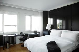 雷克雅未克101 Hotel, a Member of Design Hotels的卧室配有白色的床、书桌和窗户。
