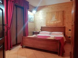 罗通达Le Chalet del Pollino的一间卧室配有一张带红色窗帘的大床