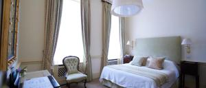 伦敦杜兰特斯酒店的一间卧室配有一张床、一把椅子和窗户。
