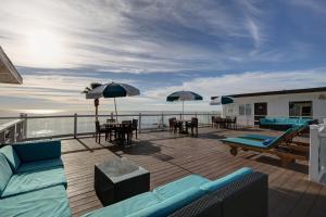拉古纳海滩卡普里拉古娜海滩精品酒店的一个带桌椅和遮阳伞的甲板