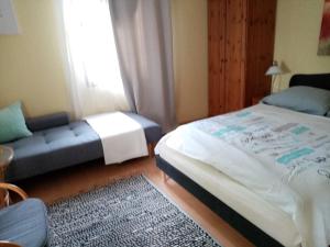 Horvátzsidány科什葛亚丽酒店的一间卧室配有一张床、一张沙发和一个窗口