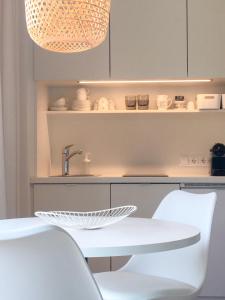 沃尔特湖畔韦尔登Appartements Gästehaus Gallob的厨房配有白色的桌子和白色的椅子