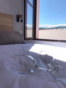 Jerez del MarquesadoHotel El Picón de Sierra Nevada的坐在床上一副玻璃杯,窗子