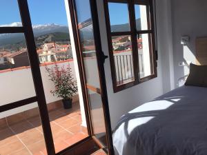 Jerez del MarquesadoHotel El Picón de Sierra Nevada的一间卧室设有一张床,享有阳台的景色
