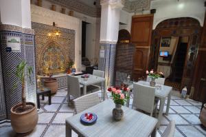 非斯雷德阿达里萨酒店的一间设有桌椅的餐厅,并种植了鲜花