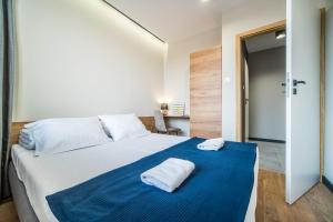 比亚韦斯托克Rint - Centrum Zamenhofa Street的一间卧室配有一张大床和两条毛巾