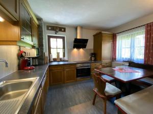 绍滕斯Ferienhaus Ötztal-Lodge的厨房配有木制橱柜、桌子和水槽。