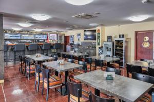 霍穆托夫阿雷娜旅馆的一间带桌椅的餐厅和一间酒吧