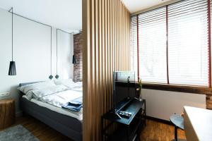 卢布林Apartament Solna - jedyny taki #Lublin的一间卧室配有一张床、一张书桌和一个窗户。