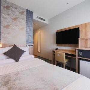 青森ART HOTEL Aomori的酒店客房配有一张床和一张带电脑的书桌