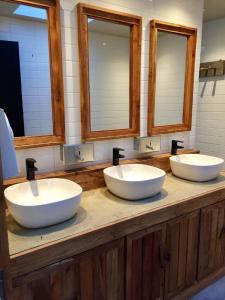纳塔列斯港Hostal Boutique Factoria Patagonia的带三面镜子的浴室内的三个盥洗盆
