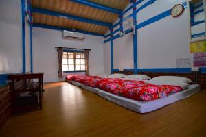 Lucao嘉義泊岸居民宿的一间位于地板上的客房,配有两张带红色枕头的床。