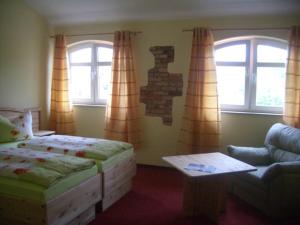 里布尼茨达姆加滕Landhotel zum Honigdieb的一间卧室配有一张床、一张沙发和窗户。