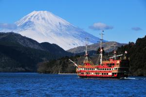 箱根麦尔维尔箱根强罗酒店的水面上的红船,底下是山