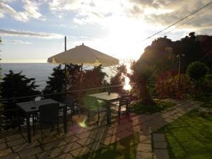 克里日亚科尔特德尔加洛酒店的一个带桌子和遮阳伞的庭院和大海