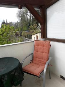 吕本瑙Ferienwohnung Wilke的橙色椅子坐在带窗户的阳台