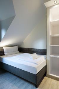 温特贝格Dorint Resort Winterberg的一间卧室设有一张床和一个书架