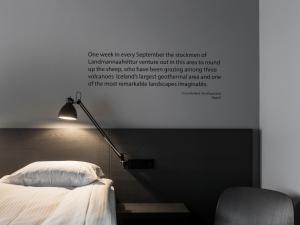 雷克雅未克Skuggi Hotel by Keahotels的墙上挂着一张床和一盏灯的照片