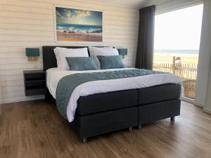 赞德沃特STRAND 21 hotelchalets的一间卧室设有一张大床,享有海景