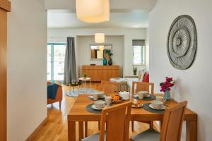 阿尔布费拉Casas Barulho Albufeira Marina的用餐室以及带桌椅的起居室。
