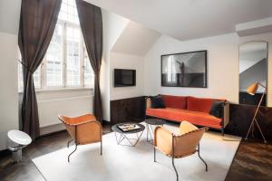 斯德哥尔摩Miss Clara by Nobis, Stockholm, a Member of Design Hotels™的客厅配有红色的沙发和椅子