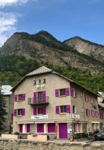 Condamine-ChâtelardLa Condaminoise的一座带粉红色和紫色门的建筑,一座山
