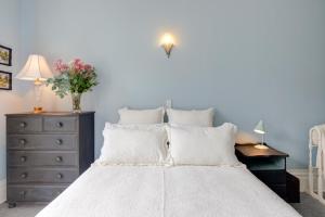 惠灵顿Thorndon Heritage Listed Villa的卧室配有一张带梳妆台的大型白色床