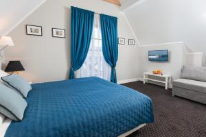弗瓦迪斯瓦沃沃Domki Hallerowka Resort的一间卧室配有蓝色的床和椅子