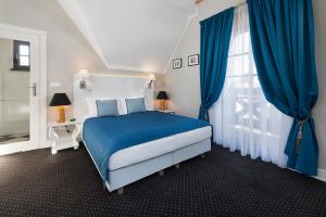 弗瓦迪斯瓦沃沃Domki Hallerowka Resort的蓝色和白色的卧室设有床和窗户