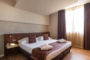 多索博诺维罗那机场会议及休闲酒店的酒店客房,配有带两条毛巾的床