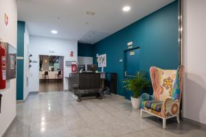 米兰达德埃布罗Hotel Abades Via Norte的医院大厅,有蓝色的墙壁和椅子