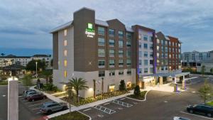 奥兰多Holiday Inn Express & Suites Orlando- Lake Buena Vista, an IHG Hotel的停车场里酒店 ⁇ 染