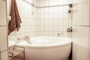 里加萨姆皮特拉玛雅宾馆的白色的浴室设有浴缸和卫生间。