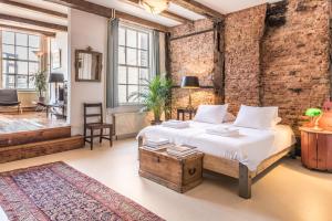 阿姆斯特丹优雅17号C运河屋公寓的一间卧室设有一张床和砖墙
