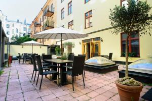 斯德哥尔摩赫尔斯登酒店集团的庭院配有桌椅和遮阳伞。