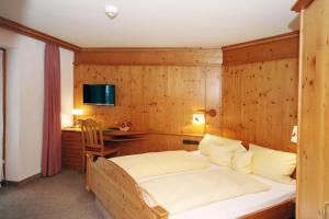 里茨勒恩阿潘松尼酒店的一间卧室配有一张木墙床