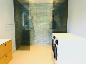 奥尔堡aday - 4 Bedroom - Modern Living Apartment - Aalborg的带淋浴和洗衣机的浴室