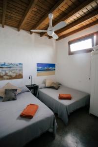 塞博河畔卡莱塔VILLA RELAX, LA GRACIOSA的配有吊扇的客房内的两张床