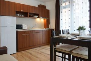圣弗拉斯Apartcomplex in Sveti Vlas Viktorio 3的厨房配有桌子和白色冰箱。