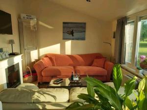 DudzeleLogies De Meerkoet的客厅配有橙色沙发和桌子