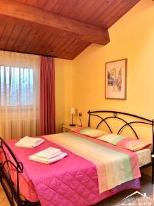 阿特里La Casetta Di Atri的一间卧室配有一张带粉色毯子的大床