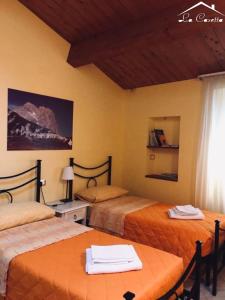 阿特里La Casetta Di Atri的客房设有两张床、一张桌子和一扇窗户。