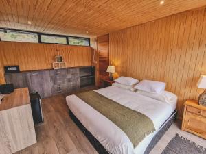 AldanaHacienda Tres Lagos的卧室配有一张木墙内的大床