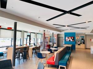 博蒙特Avid hotels - Beaumont, an IHG Hotel的一间带桌椅和天花板的餐厅