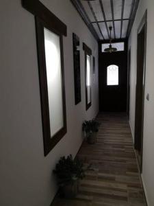 MariaíAnna Studios的一条带白色墙壁和黑色门的走廊