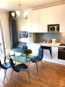 文茨皮尔斯VILLA FLORANCE apartments with terraces & parking的厨房配有玻璃桌和椅子