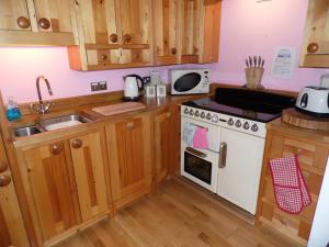 卡比斯贝Seaside Apartment的厨房配有木制橱柜和白色炉灶烤箱。